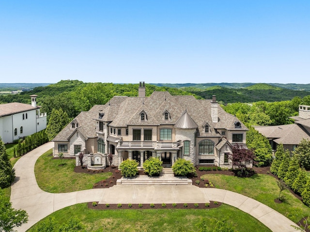 443 Canterbury Rise, Franklin, TN 37067 - french country style house featuring a chimney, stone siding, a balcony, and a standing seam roof