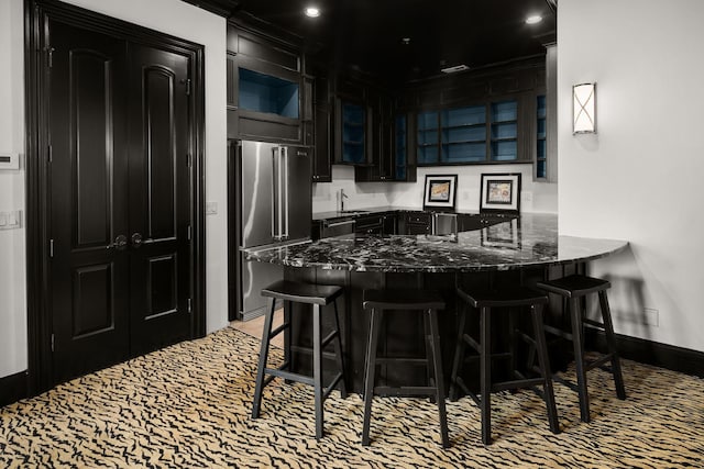 443 Canterbury Rise, Franklin, TN 37067 - kitchen with high quality fridge, dark stone countertops, glass insert cabinets, a peninsula, and baseboards