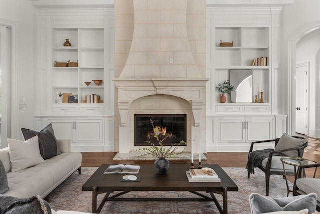 443 Canterbury Rise, Franklin, TN 37067 - living room with built in shelves, dark wood-style flooring, a large fireplace, and arched walkways
