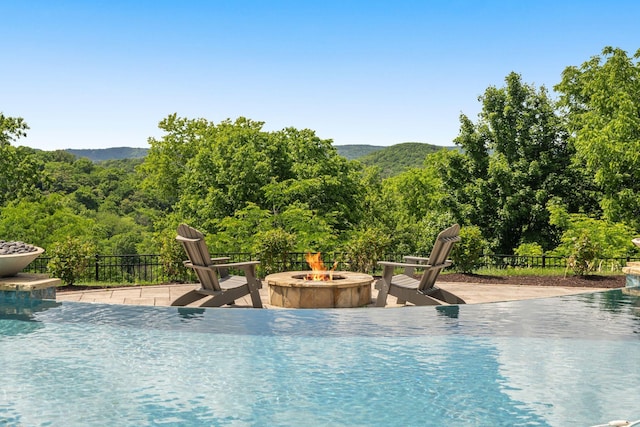 443 Canterbury Rise, Franklin, TN 37067 - view of swimming pool with a fire pit, fence, a mountain view, and a wooded view