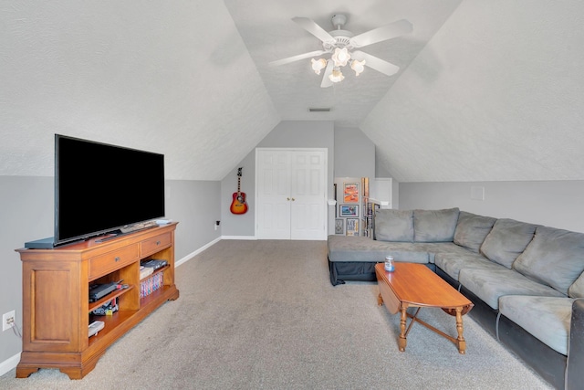 carpeted living area featuring vaulted ceiling, baseboards, and ceiling fan