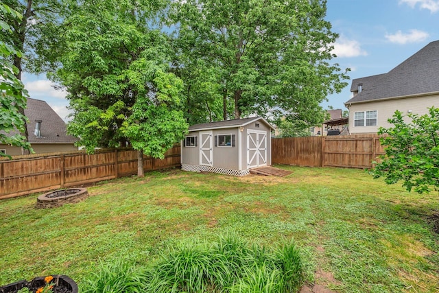 view of yard with an outdoor fire pit, a storage shed, and an outbuilding