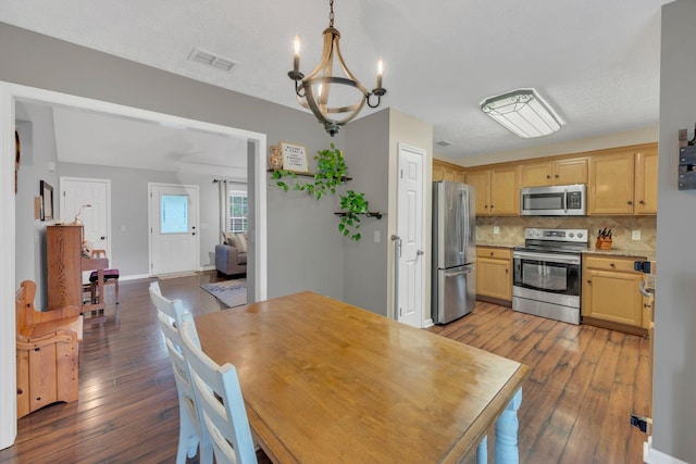 dining area featuring dark wood-style floors, a chandelier, and baseboards