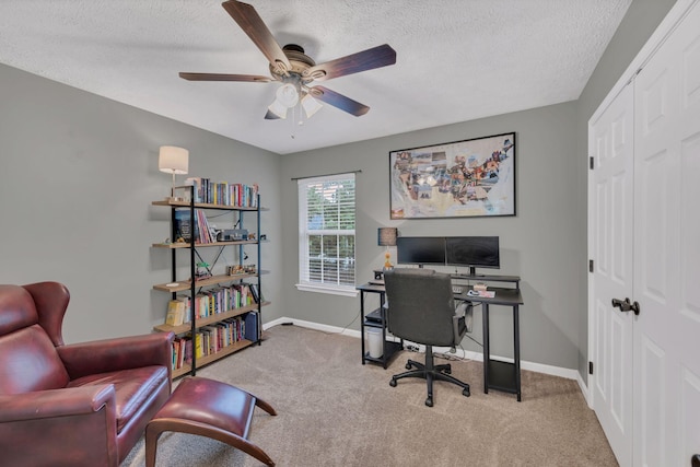 carpeted office space featuring baseboards, a ceiling fan, and a textured ceiling