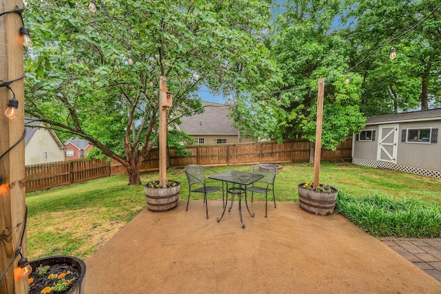 view of patio featuring outdoor dining space, a shed, and an outbuilding