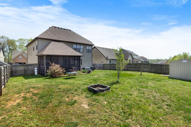 1685 Apache Way, Clarksville, TN 37042 - back of property with an outdoor fire pit, a sunroom, a storage unit, a shingled roof, and an outbuilding