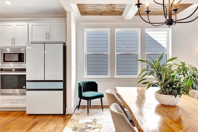 kitchen featuring appliances with stainless steel finishes, a chandelier, light wood-style flooring, and wood ceiling
