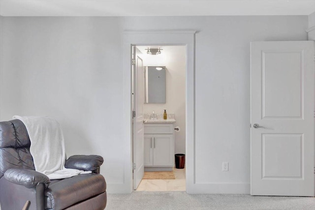 sitting room featuring light carpet, bar area, and baseboards