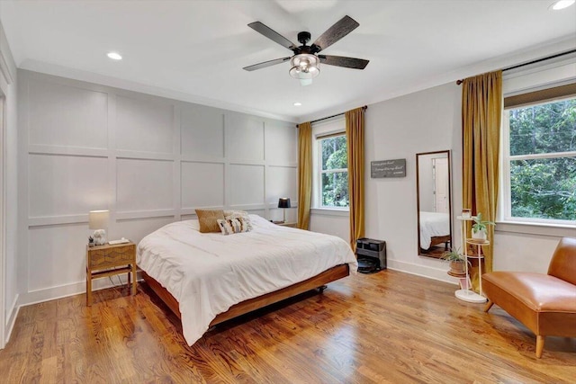 bedroom with a decorative wall, light wood finished floors, recessed lighting, and a ceiling fan