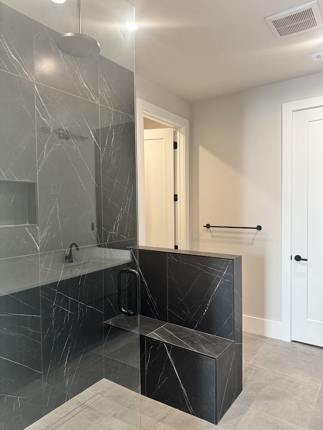 bathroom featuring a marble finish shower and baseboards