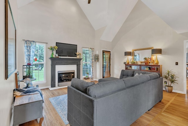 213 Hickory Trl, White House, TN 37188 - living area with a fireplace with flush hearth, baseboards, high vaulted ceiling, and light wood-type flooring
