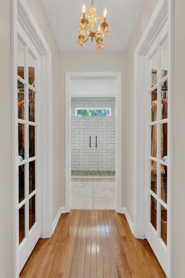 213 Hickory Trl, White House, TN 37188 - corridor with a chandelier, light wood-type flooring, and baseboards