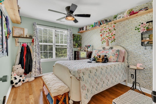 213 Hickory Trl, White House, TN 37188 - bedroom featuring baseboards, wood finished floors, an accent wall, and ceiling fan