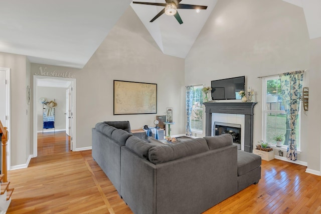 213 Hickory Trl, White House, TN 37188 - living area with light wood-style floors, ceiling fan, healthy amount of natural light, a glass covered fireplace, and high vaulted ceiling