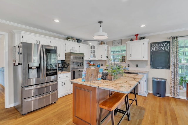 213 Hickory Trl, White House, TN 37188 - kitchen with stainless steel appliances, white cabinets, healthy amount of natural light, ornamental molding, and light wood-style floors