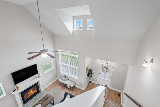 5902 Covent Ln, Smyrna, TN 37167 - living area with a glass covered fireplace, high vaulted ceiling, light wood-style flooring, a ceiling fan, and baseboards