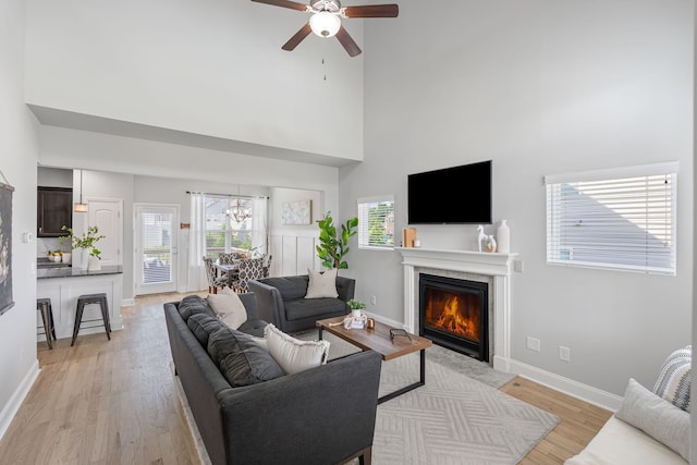 5902 Covent Ln, Smyrna, TN 37167 - living area with a high ceiling, a ceiling fan, a chandelier, a lit fireplace, and light wood finished floors