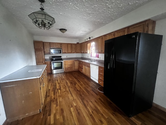 555 Oakley Allons Rd, Allons, TN 38541 - kitchen featuring stainless steel appliances, dark wood-style flooring, a textured ceiling, brown cabinets, and decorative light fixtures