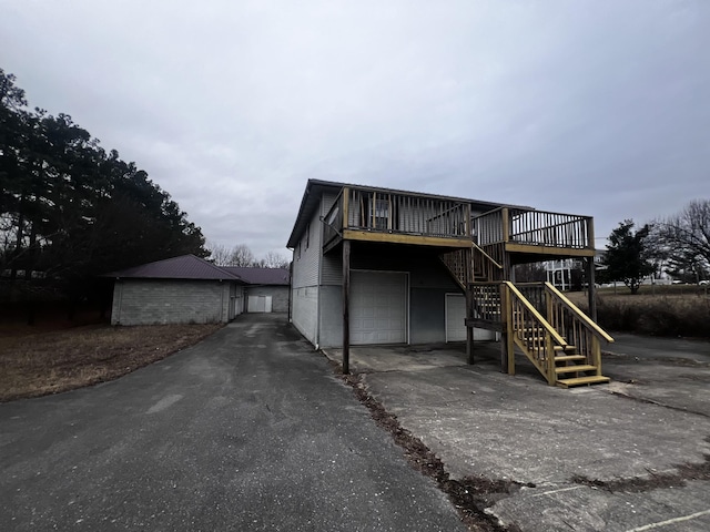 555 Oakley Allons Rd, Allons, TN 38541 - view of front of property featuring asphalt driveway, a garage, stairway, and a wooden deck