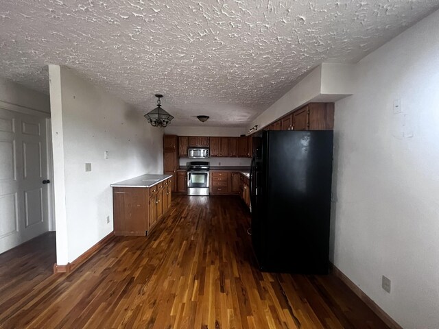 555 Oakley Allons Rd, Allons, TN 38541 - kitchen featuring freestanding refrigerator, stove, stainless steel microwave, dark wood-style flooring, and a textured ceiling