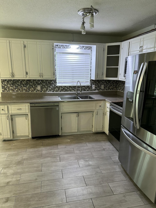 2514 Maplewood Dr, Chattanooga, TN 37421 - kitchen featuring appliances with stainless steel finishes, a sink, dark countertops, wood finish floors, and a textured ceiling