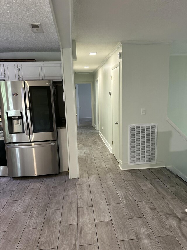 2514 Maplewood Dr, Chattanooga, TN 37421 - kitchen with stainless steel refrigerator with ice dispenser, white cabinets, wood finish floors, ornamental molding, and baseboards