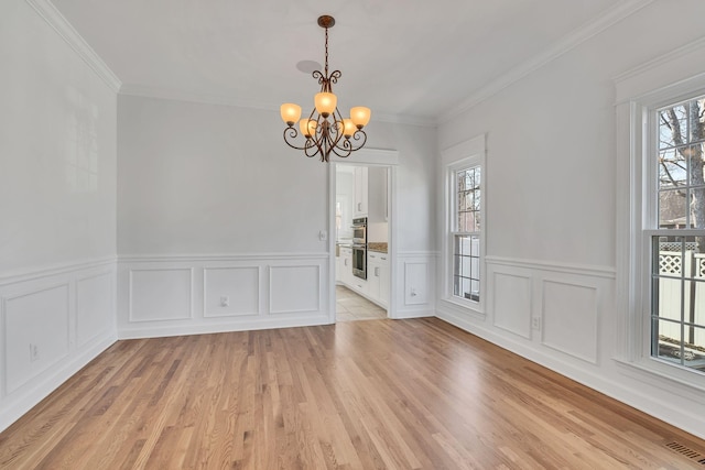 3033 Tybee Trl, Murfreesboro, TN 37127 - unfurnished dining area with a chandelier, a decorative wall, a wainscoted wall, light wood finished floors, and crown molding