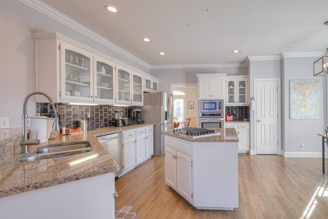 5784 Rock Springs Rd, Smyrna, TN 37167 - kitchen featuring appliances with stainless steel finishes, a sink, decorative backsplash, white cabinetry, and a center island