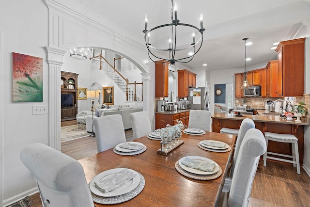 1013 Nealcrest Cir, Spring Hill, TN 37174 - dining area with a chandelier, recessed lighting, ornate columns, crown molding, and wood finished floors