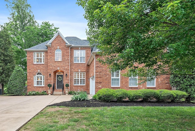 1013 Nealcrest Cir, Spring Hill, TN 37174 - view of front of property with a front yard, concrete driveway, brick siding, and roof with shingles