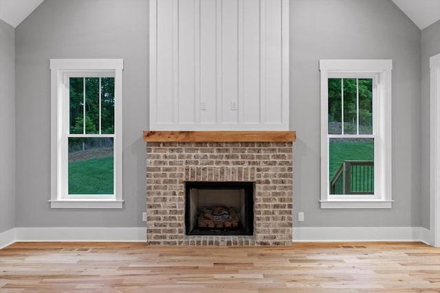 264 Goose Creek Cir, Soddy Daisy, TN 37379 - unfurnished living room featuring vaulted ceiling, wood finished floors, a fireplace, and baseboards