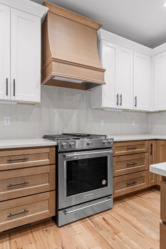 264 Goose Creek Cir, Soddy Daisy, TN 37379 - kitchen with stainless steel range with gas cooktop, custom exhaust hood, decorative backsplash, and white cabinetry