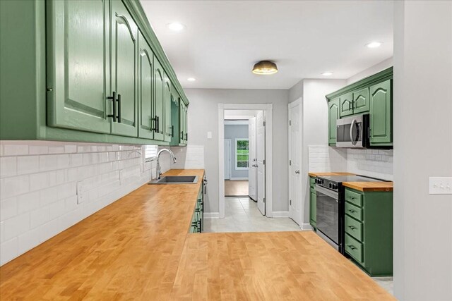 205 Jackson St, Cowan, TN 37318 - kitchen with green cabinetry, stainless steel appliances, a sink, wooden counters, and decorative backsplash
