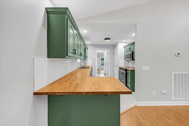 205 Jackson St, Cowan, TN 37318 - kitchen with green cabinets, stainless steel appliances, a peninsula, decorative backsplash, and recessed lighting