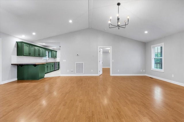 205 Jackson St, Cowan, TN 37318 - unfurnished living room with a chandelier, lofted ceiling, light wood-type flooring, baseboards, and a sink