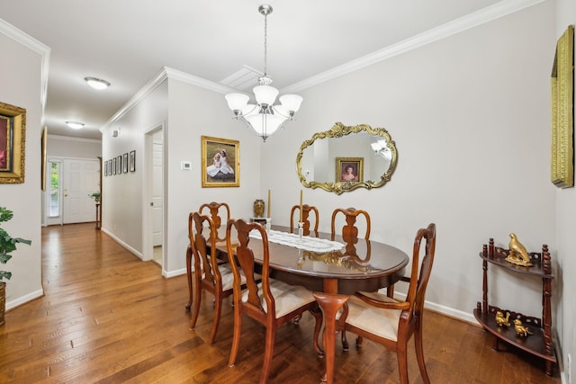 dining space with a chandelier, ornamental molding, hardwood / wood-style floors, and baseboards