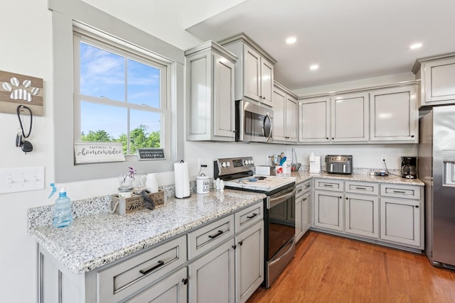 706 Kirbytown Rd, Lafayette, TN 37083 - kitchen featuring appliances with stainless steel finishes, gray cabinets, light wood-style floors, light stone counters, and recessed lighting