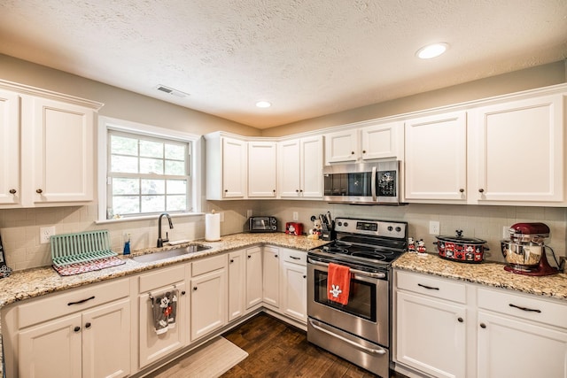 1461 Round Rock Dr, Murfreesboro, TN 37128 - kitchen with appliances with stainless steel finishes, a sink, dark wood-style flooring, white cabinetry, and a textured ceiling