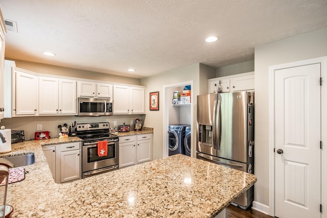1461 Round Rock Dr, Murfreesboro, TN 37128 - kitchen featuring stainless steel appliances, washer and clothes dryer, a peninsula, white cabinetry, and recessed lighting