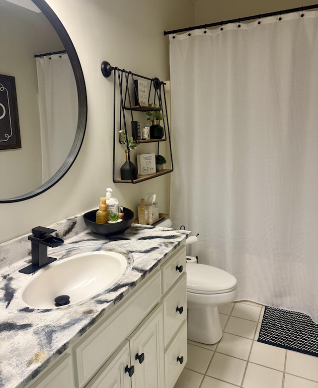 bathroom with tile patterned flooring, vanity, and toilet