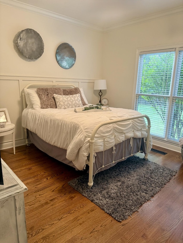 bedroom featuring crown molding and wood finished floors