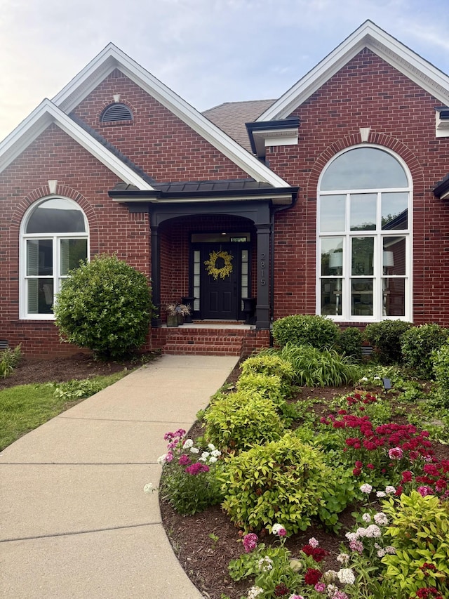 property entrance featuring brick siding and a porch