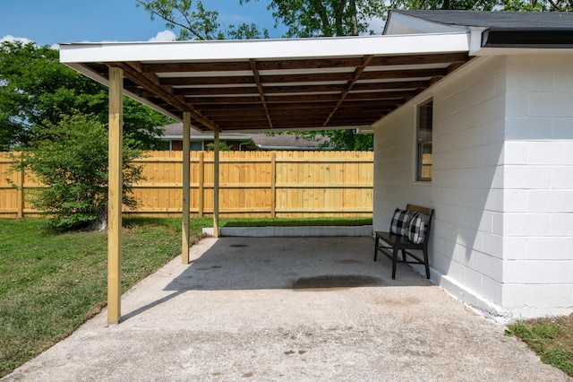 view of patio / terrace featuring fence and a carport