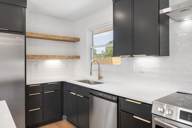 kitchen with stainless steel appliances, a sink, backsplash, and light countertops