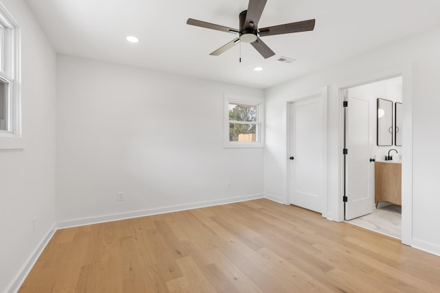 unfurnished bedroom with light wood-style floors, baseboards, recessed lighting, and ensuite bath