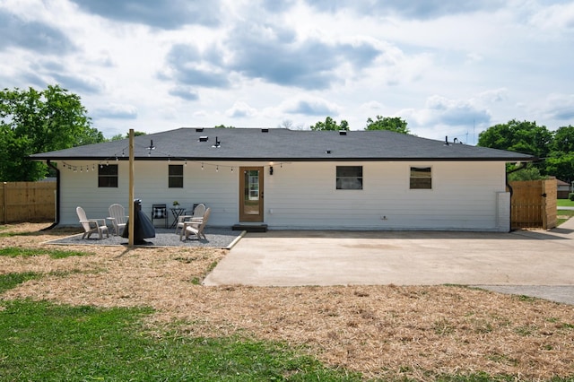 rear view of house with a patio area and fence