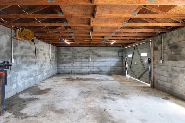 below grade area featuring a garage and concrete block wall
