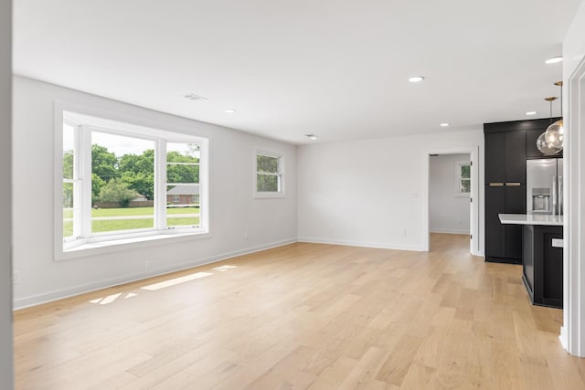 unfurnished living room with baseboards, light wood-type flooring, and recessed lighting