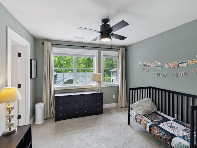 bedroom featuring light carpet, a ceiling fan, and baseboards