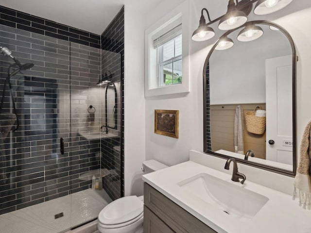 bathroom with a stall shower, toilet, and vanity